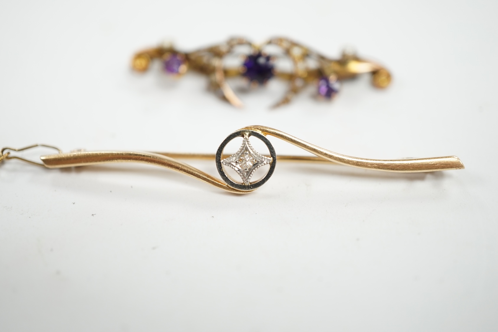 An Edwardian 15ct and diamond set crossover bar brooch, 57mm, gross weight 3.9 grams, together with a similar 9ct gold, amethyst and seed pearl set bar brooch, gross weight 2.3 grams. Condition - fair